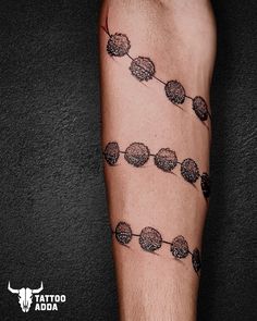 a man's arm with tattoos on it that have balls and chains attached to them