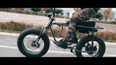 a man riding on the back of a motorcycle down a street with his foot in the air