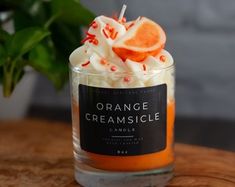 an orange creamsicle candle with whipped cream and sprinkles