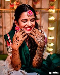 a smiling woman with henna on her hands