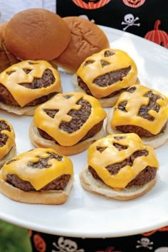 some hamburgers with cheese on them sitting on a plate