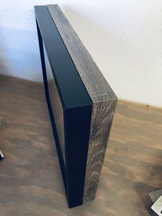 a wooden shelf sitting on top of a hard wood floor next to a white wall