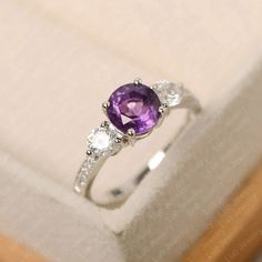 This ring features a 7*7 mm round cut amethyst. Customization is available. It is made by hand, and it will take about 7 days to finish the ring after your payment is completed. Main stone: 7*7 mm round cut Main stone weight:1.25 ct Metal type: sterling silver /14k gold Accent stone: cz Customization is available, just fee free to contact me, it is free to engrave inside the ring, it is free, you can leave a ntoe with your order, but it will be great no more than 15 letter. Any question, just le Luo Jewelry, Amethyst Engagement Rings, February Birthstone Ring, Amethyst Ring Engagement, Silver Engagement Ring, Engagement Ring For Women, Purple Band, February Birthstone, Ring Photos