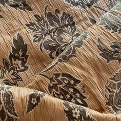 the fabric is brown and black with flowers on it, as well as an intricate pattern