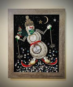 a snowman made out of glass and beads in a wooden frame on the wall