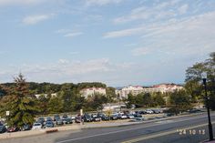 cars are parked on the side of the road in front of some buildings and trees