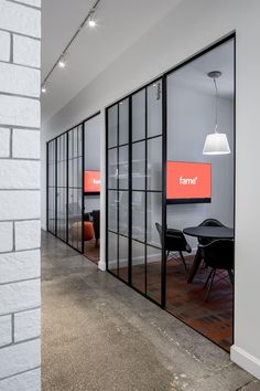 an office with glass walls and chairs in front of the doors that lead to another room