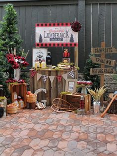 an outdoor bar set up for a lumber themed party with lots of wood signs and decorations