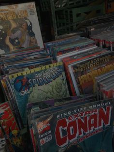 many comic books are stacked on top of each other in this pile, with the covers pulled back