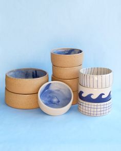 five ceramic bowls are stacked on top of each other in front of a blue background