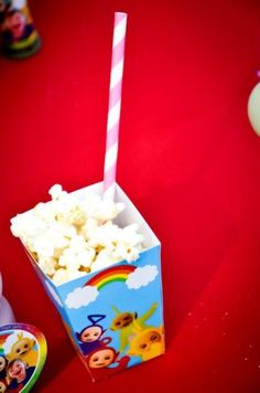 there is a small box of popcorn next to a cup with a straw in it