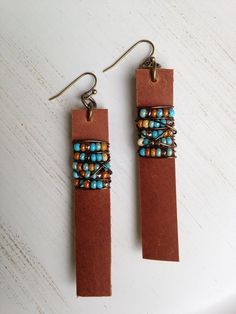 two brown leather earrings with beads on them