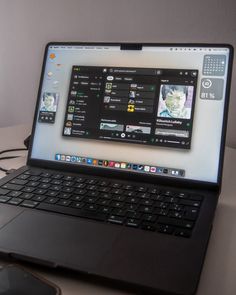 an open laptop computer sitting on top of a table next to a cell phone and mouse