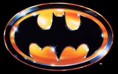 the batman symbol is shown on a black background with orange and blue lights around it