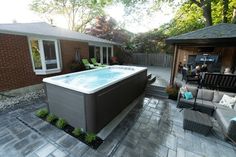 a backyard with a hot tub and patio furniture