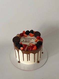 a white cake with chocolate and fruit toppings