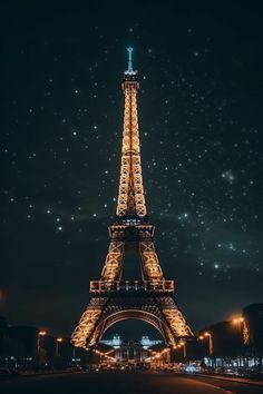 the eiffel tower lit up at night with stars in the sky above it