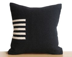 a black and white pillow sitting on top of a wooden table