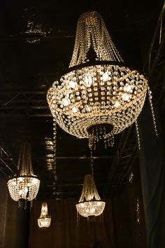 a chandelier hanging from the ceiling in a room with other lights on it