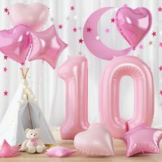 the number ten balloon is next to some balloons and a teddy bear in front of it