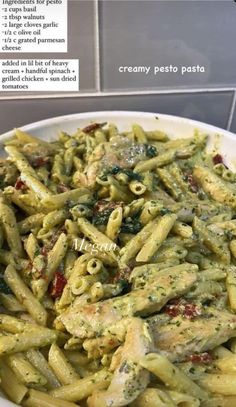 pasta with pesto sauce and chicken in a white bowl on a counter top next to a sign that says creamy pesto pasta