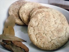 three cookies on a white plate with leaves