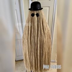 a mannequin with long blonde hair wearing a top hat and black eye glasses