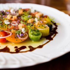 a white plate topped with lots of different types of food on top of a wooden table