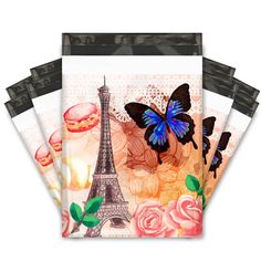 three envelopes with the eiffel tower and roses on them, one has a blue butterfly