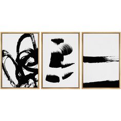 three black and white paintings hanging on a wall