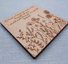 a wooden plaque with flowers and words engraved on it