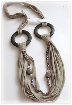 two necklaces are hanging on a white surface with black rings and beaded beads