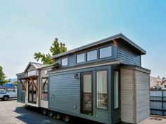 a tiny house on wheels parked in a parking lot