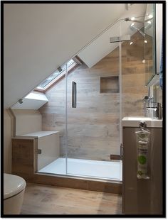 an attic bathroom with a skylight above the toilet and bathtub, along with a walk - in shower