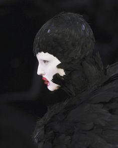 a woman with black feathers on her head