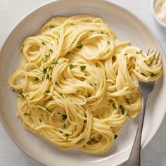 a white plate topped with pasta and parsley