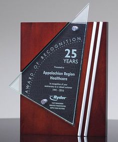 an award for 25 years is displayed on a wooden plaque with white and black stripes