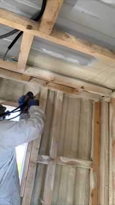 a man is working on the ceiling in his house