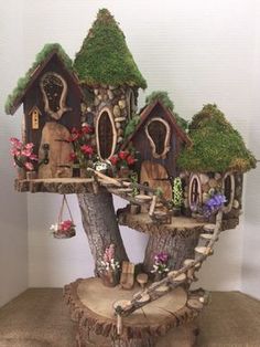 a tree stump with houses on it and flowers growing out of the trees around them