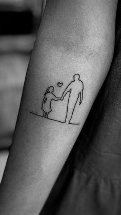 a small tattoo on the arm of a man and woman holding each other's hands