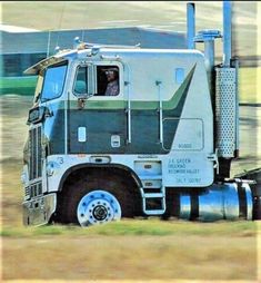 a large semi truck driving down a rural road