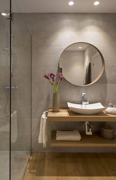 a bathroom with a sink, mirror and towel rack in the shower area is shown