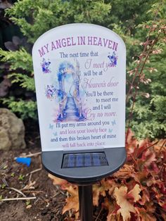 an angel in heaven sign on top of a metal pole next to some leaves and bushes