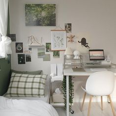 a bedroom with white furniture and pictures on the wall above the bed, along with a computer desk