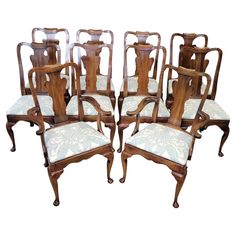 a set of eight antique dining chairs with upholstered backrests and arms