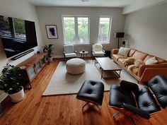 a living room filled with furniture and a flat screen tv mounted on the wall above it