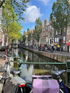 bicycles are parked along the side of a canal