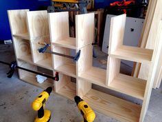 two drillers are sitting on the floor next to some shelves