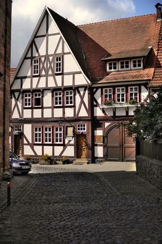 an old building with many windows on the side of it and a car parked in front of it