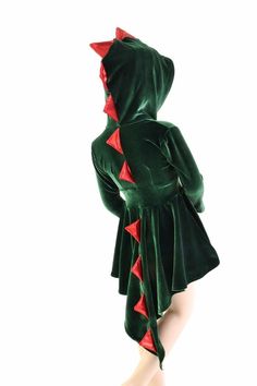 a woman in a green dress with red stars on the back and hoodie over her head